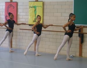 Girls working on form in ballet class.